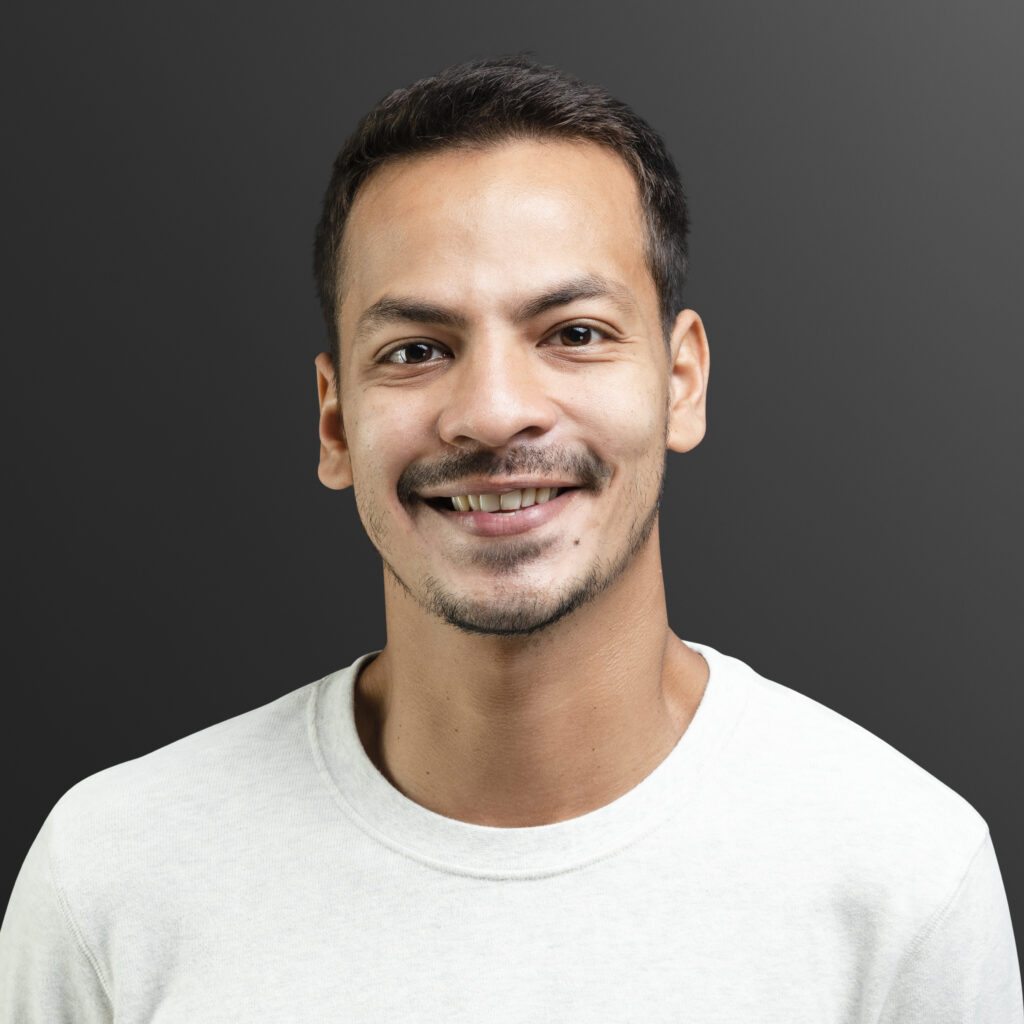 Professional portrait of a smiling man in a business suit and glasses, suitable for a corporate profile or testimonial.
